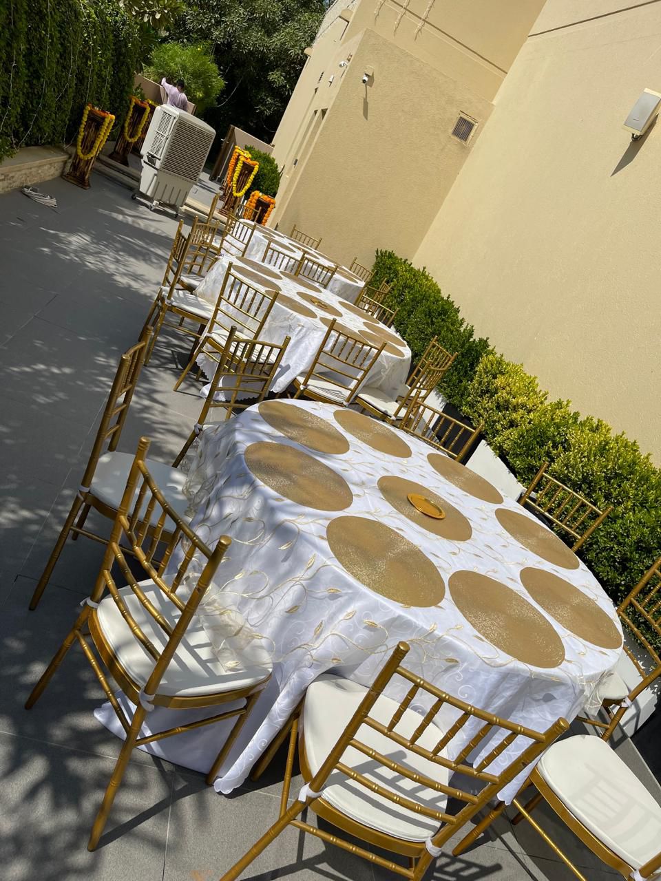 Round tables with gold chargers and chiavari chairs for rental