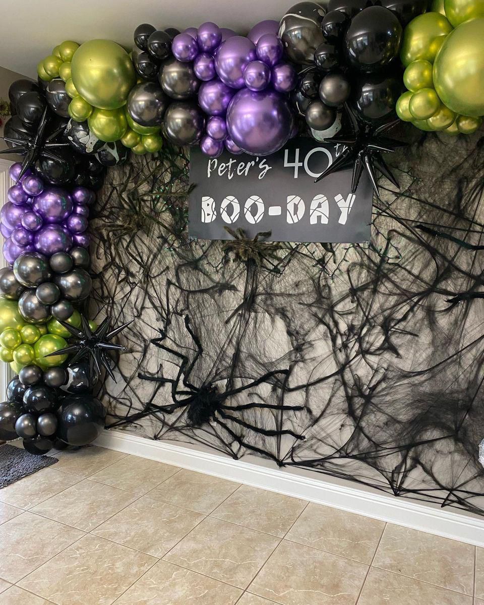 Spiderweb birthday backdrop with balloons for themed event
