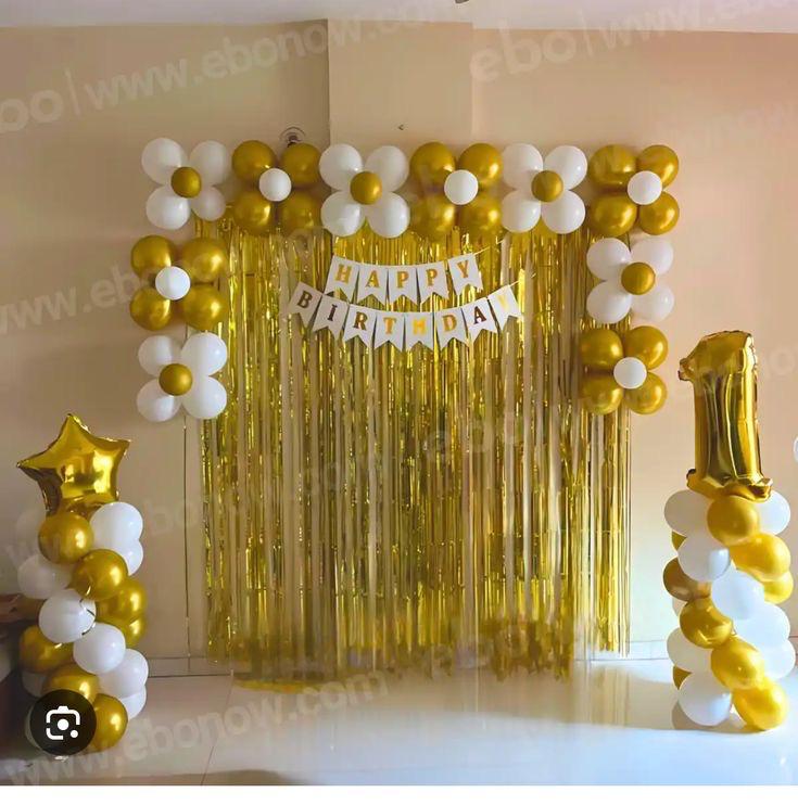 Basic birthday backdrop with white and gold balloons, fringe curtain, and number balloon